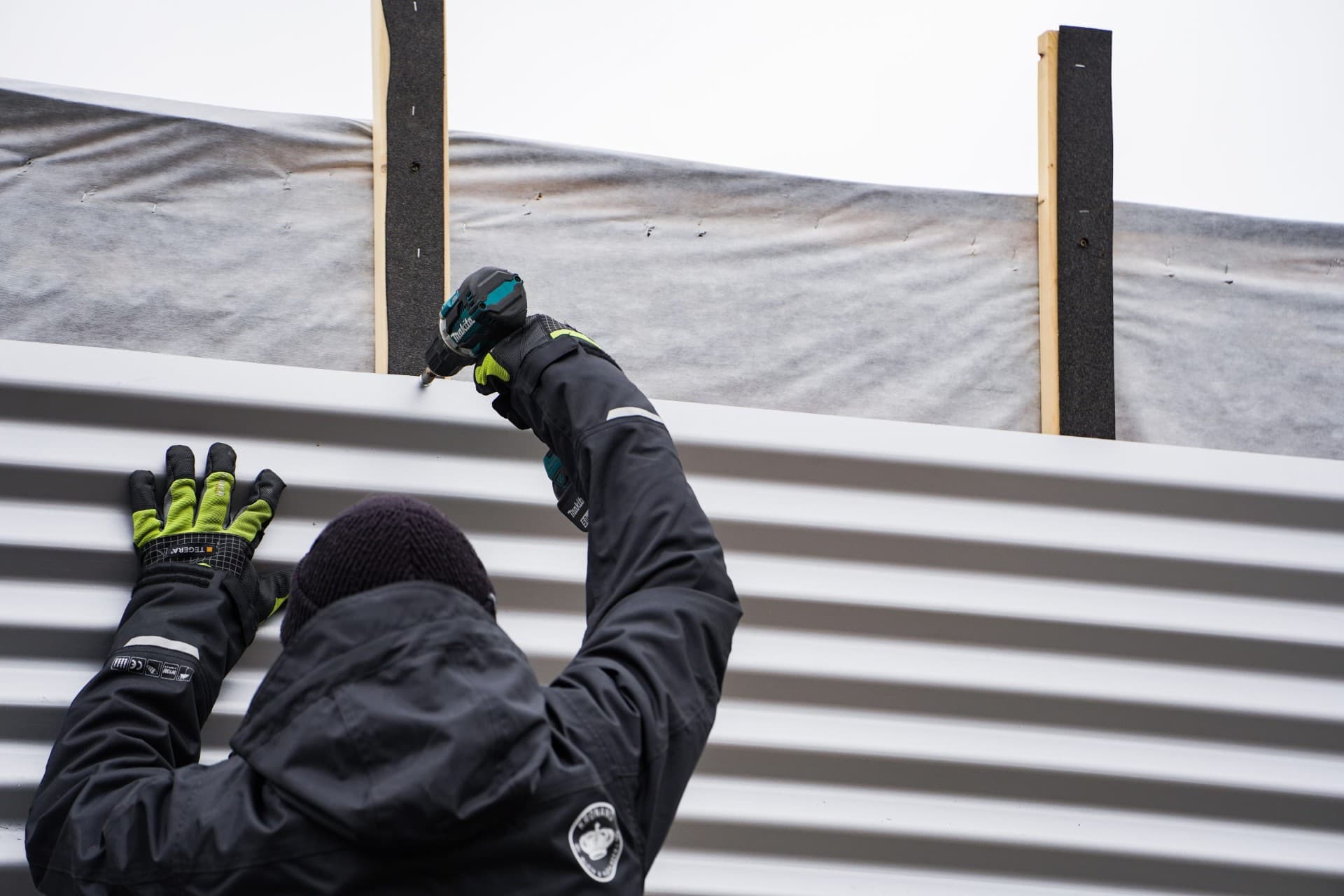 Plåtslagare från Kronans monterar fasadplåt med Makita-borrmaskin
